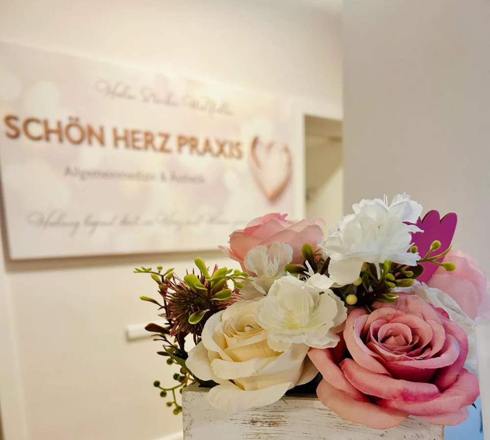 Blumen und das Schön Herz Praxis Schild im Empfangsbereich